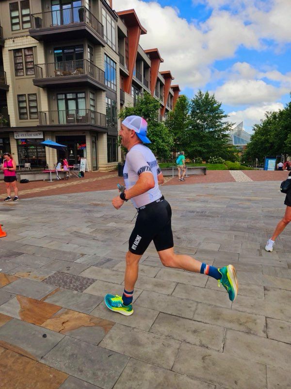 A man running on a sidewalk with a building in the background