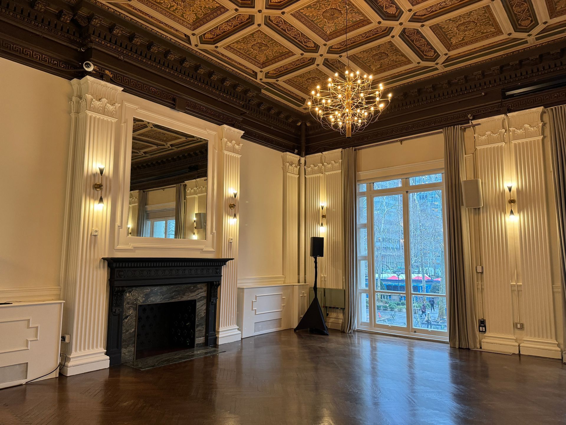 A large empty room with a fireplace and a chandelier.