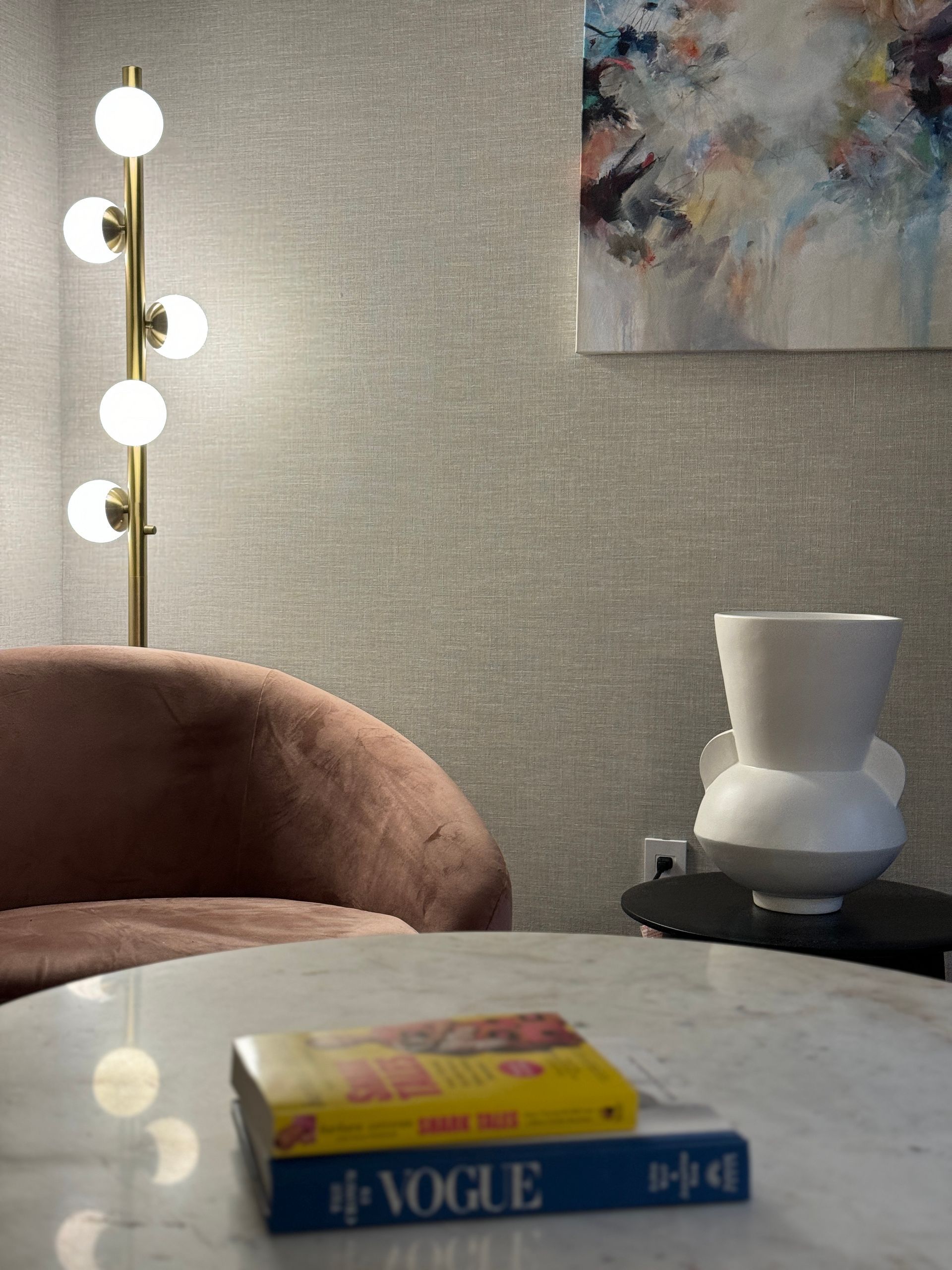 A vogue book is sitting on a table next to a vase.