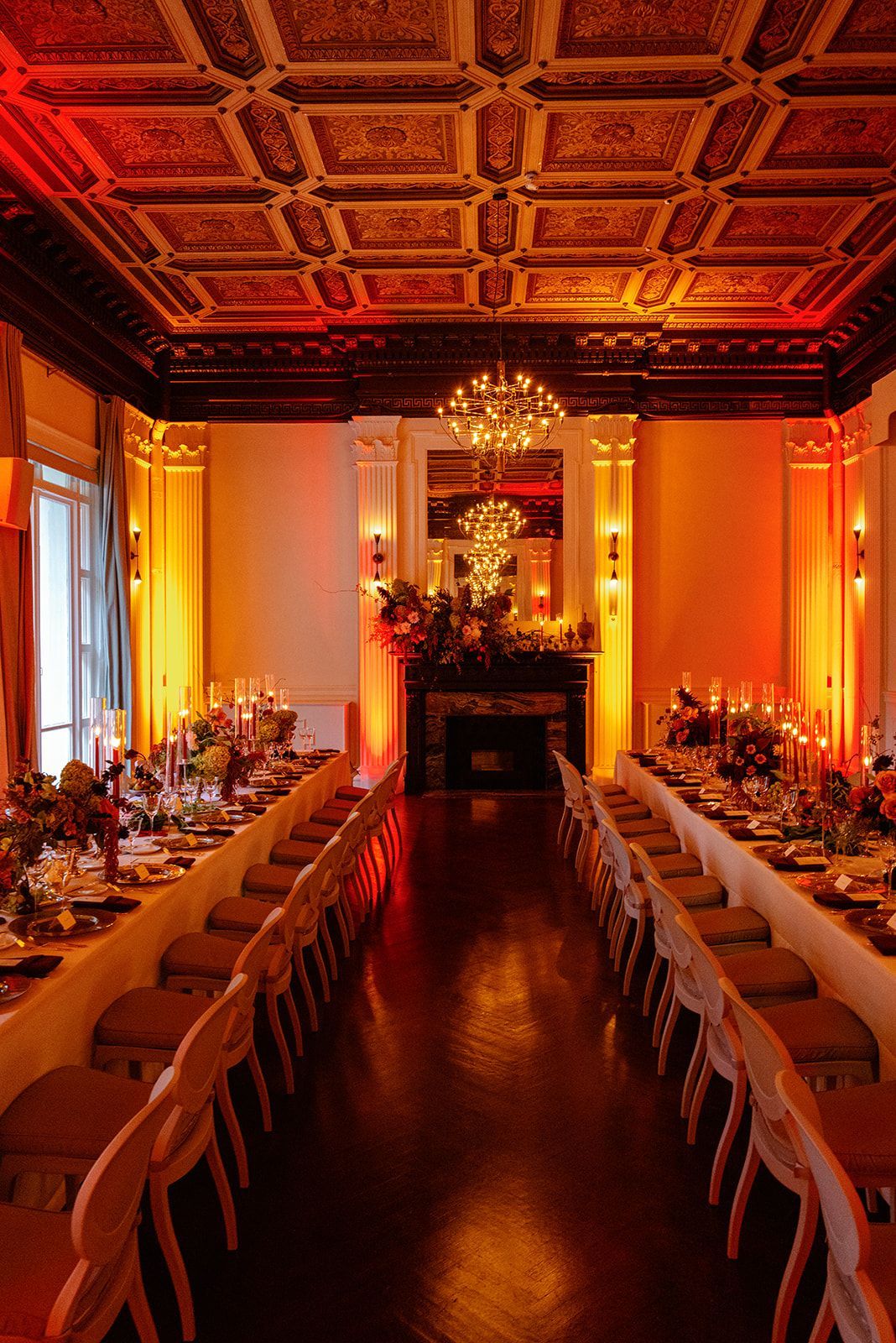 A long table and chairs in a room with a fireplace.