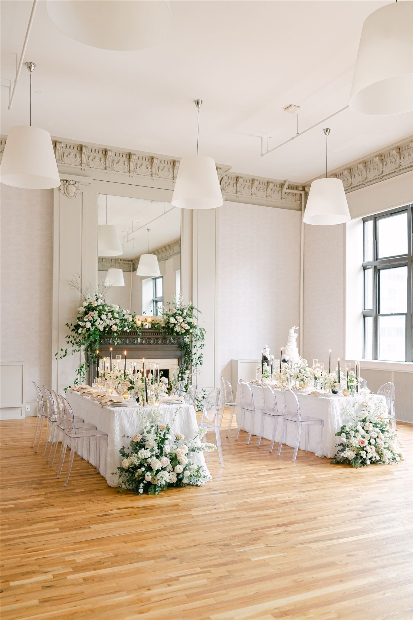 there is a long table with flowers on it in the middle of the room .