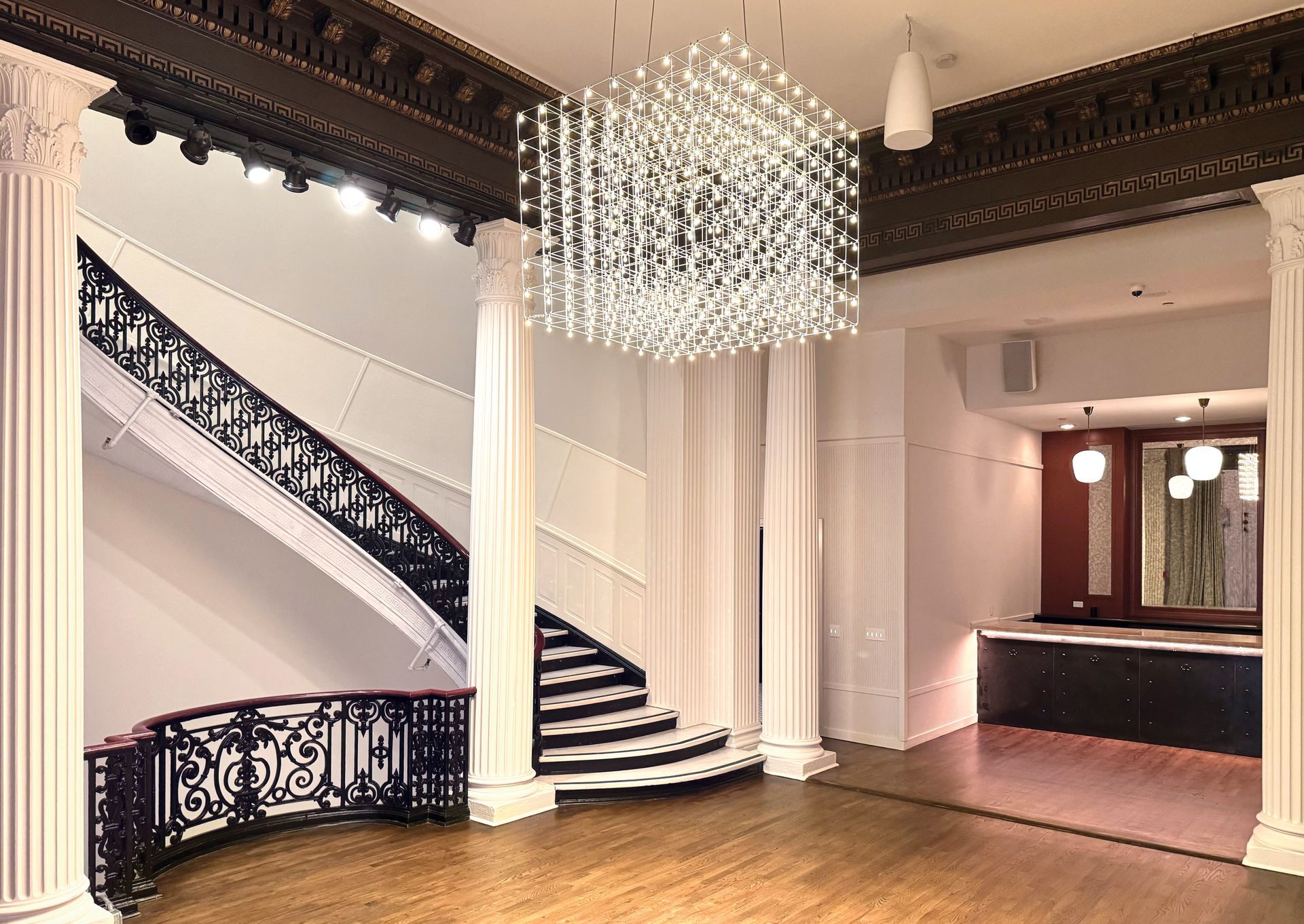 A large room with a staircase and a chandelier hanging from the ceiling