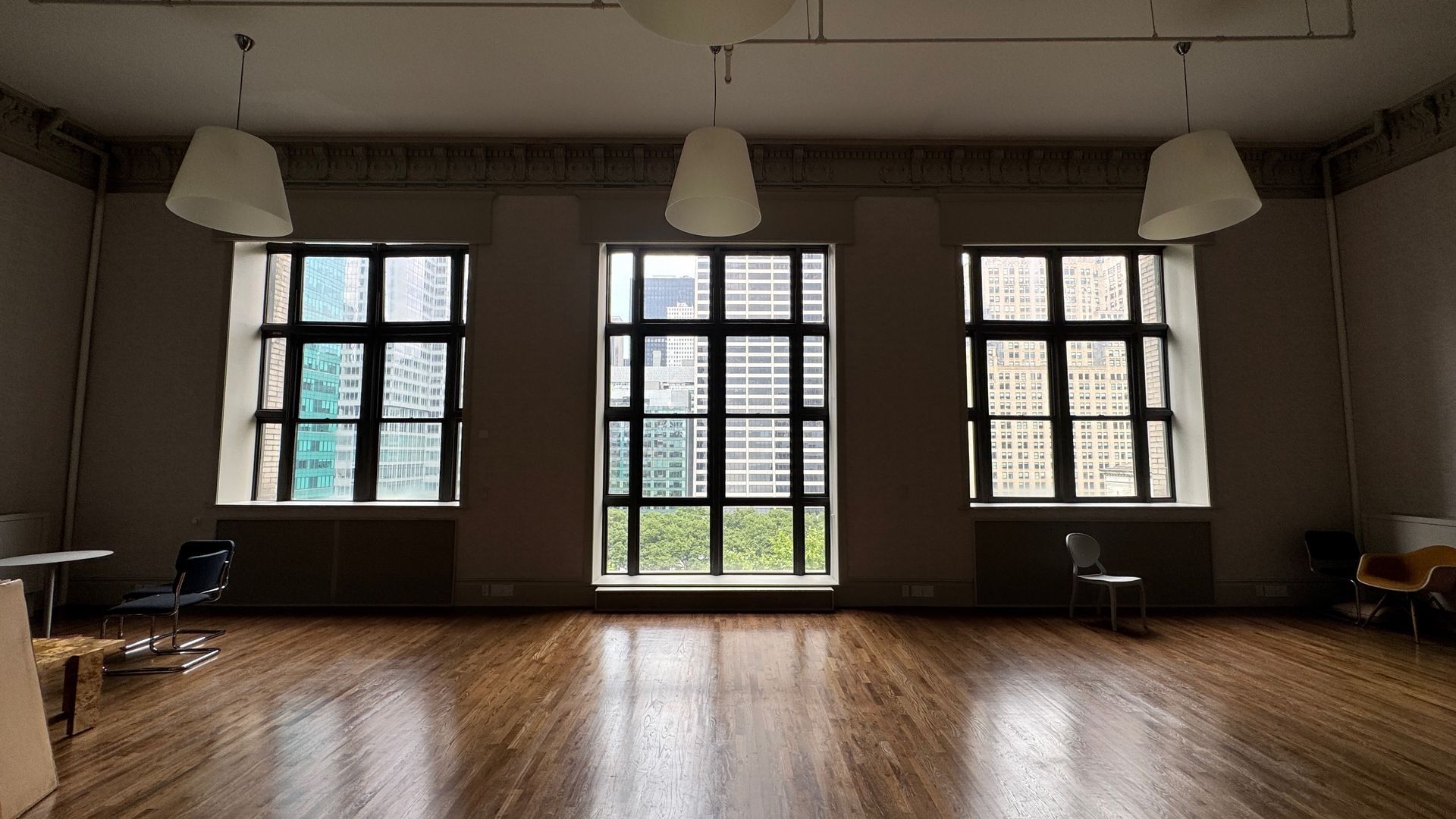 A large empty room with lots of windows and a wooden floor.