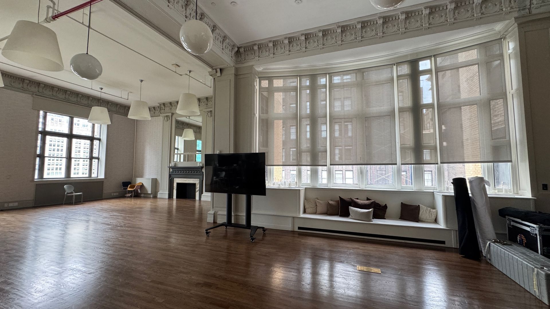 A large empty room with a lot of windows and a flat screen tv on a stand.