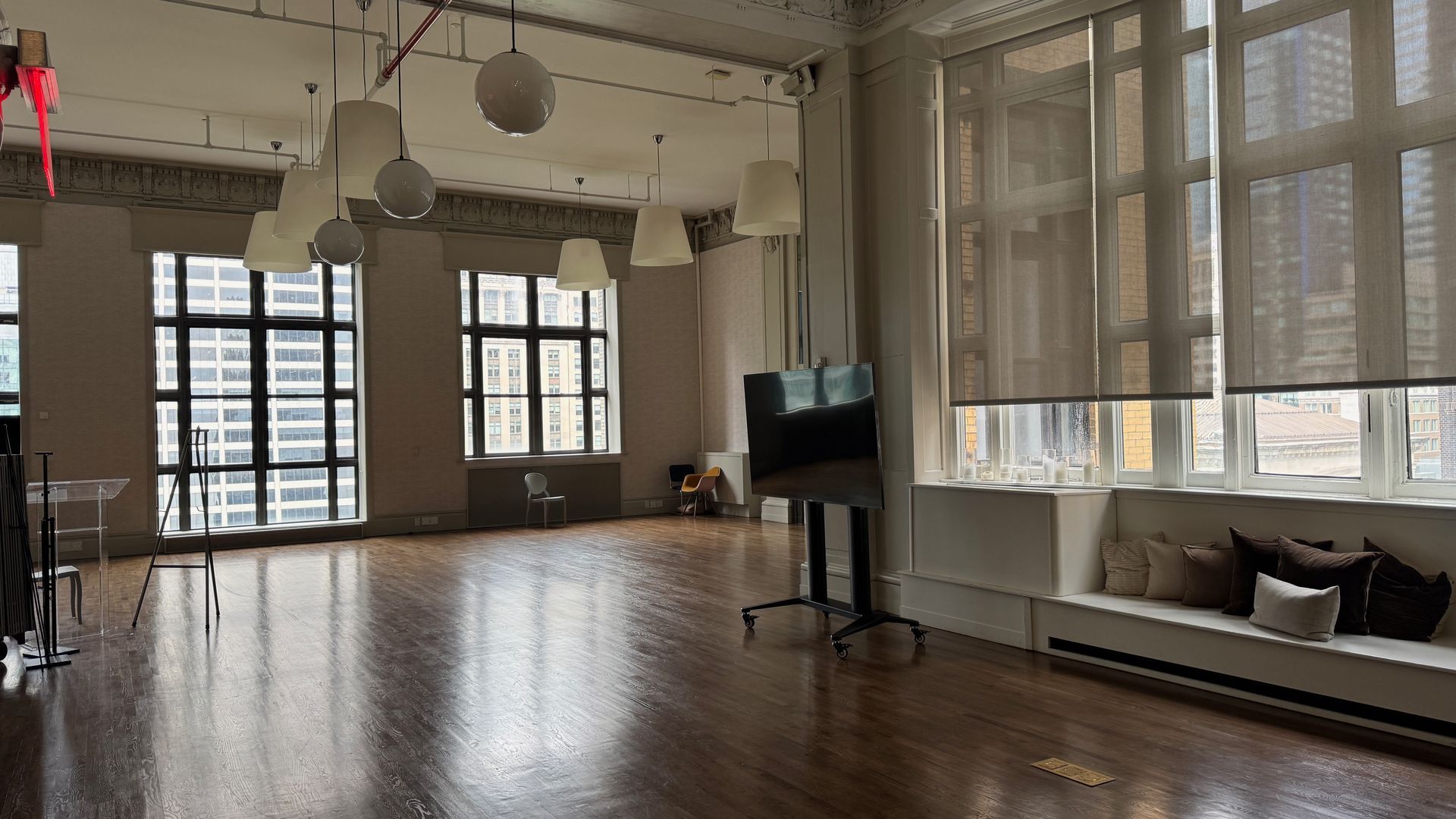 A large empty room with lots of windows and wooden floors.