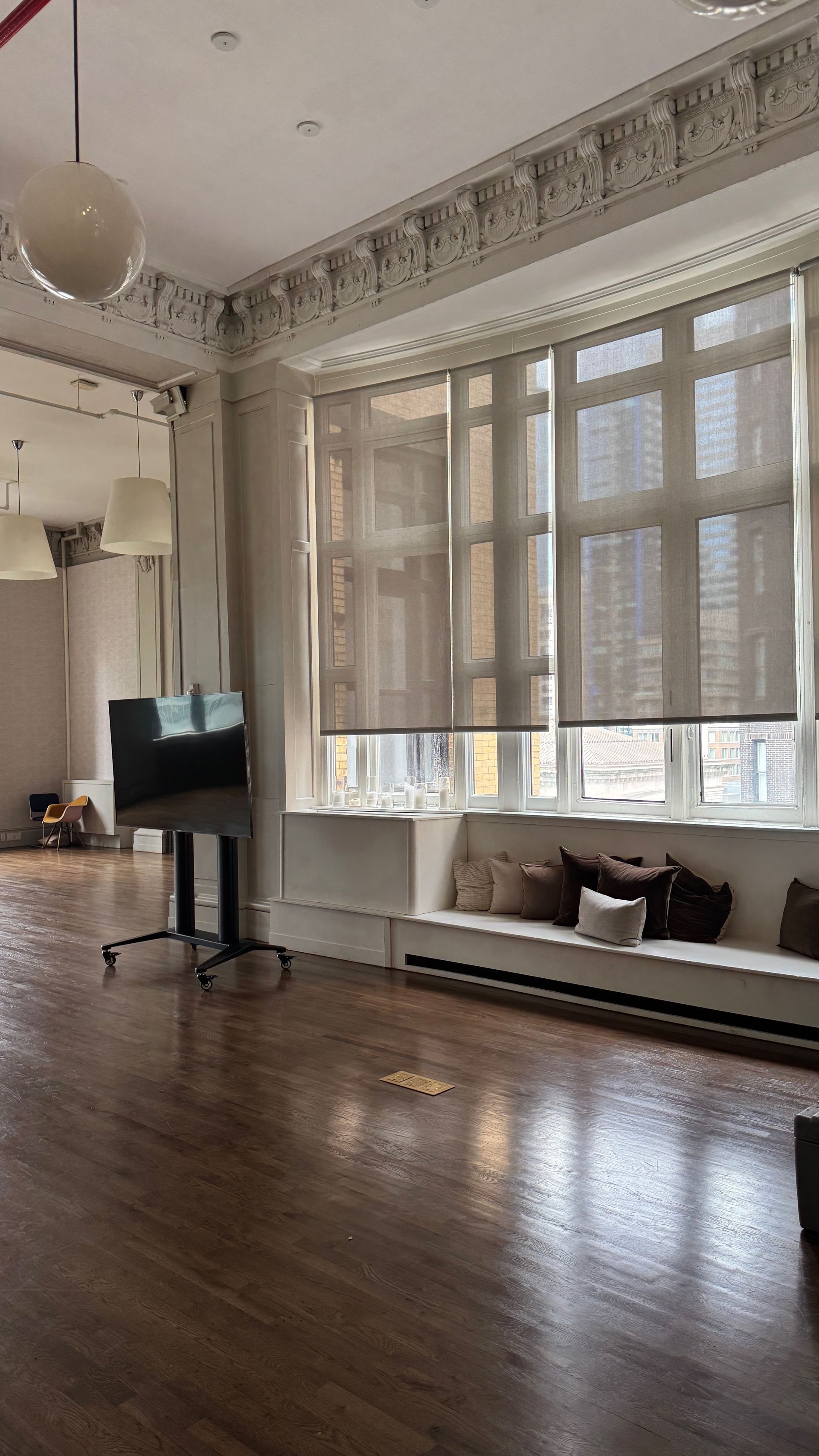 A large empty room with a lot of windows and wooden floors.