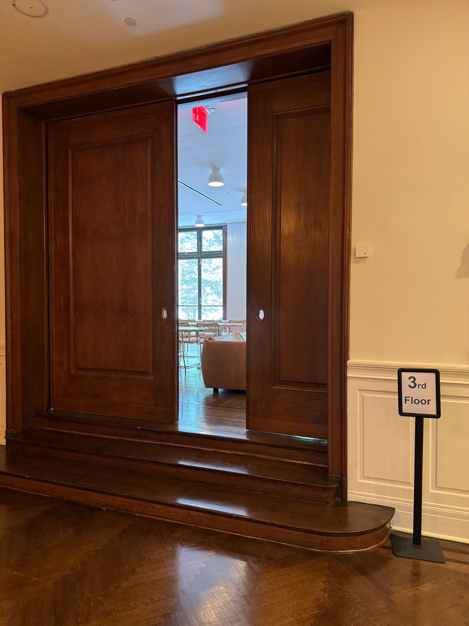 A wooden door is open to a room with a sign that says 3rd floor.