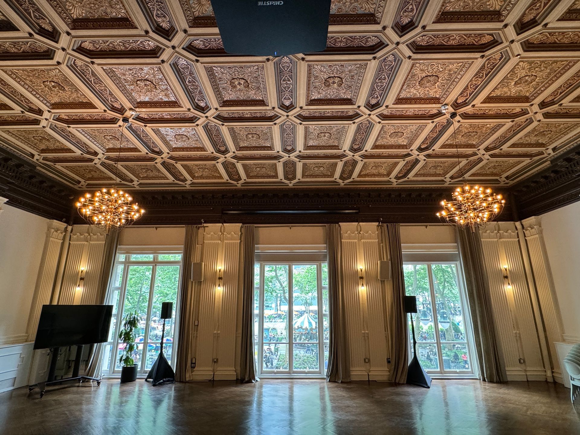 A large room with a ceiling that is very ornate and a lot of windows.