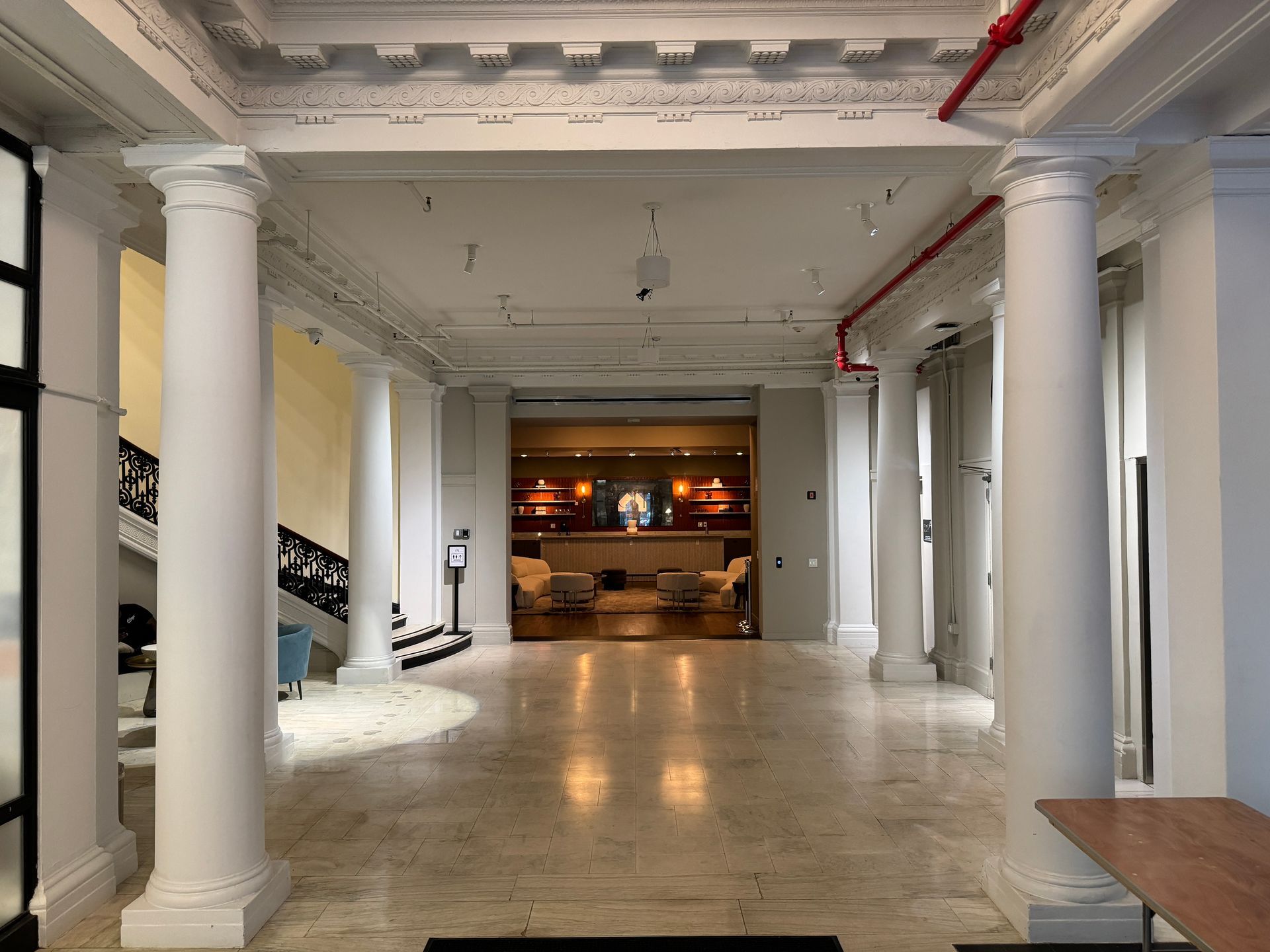 A large hallway with columns and stairs in a building