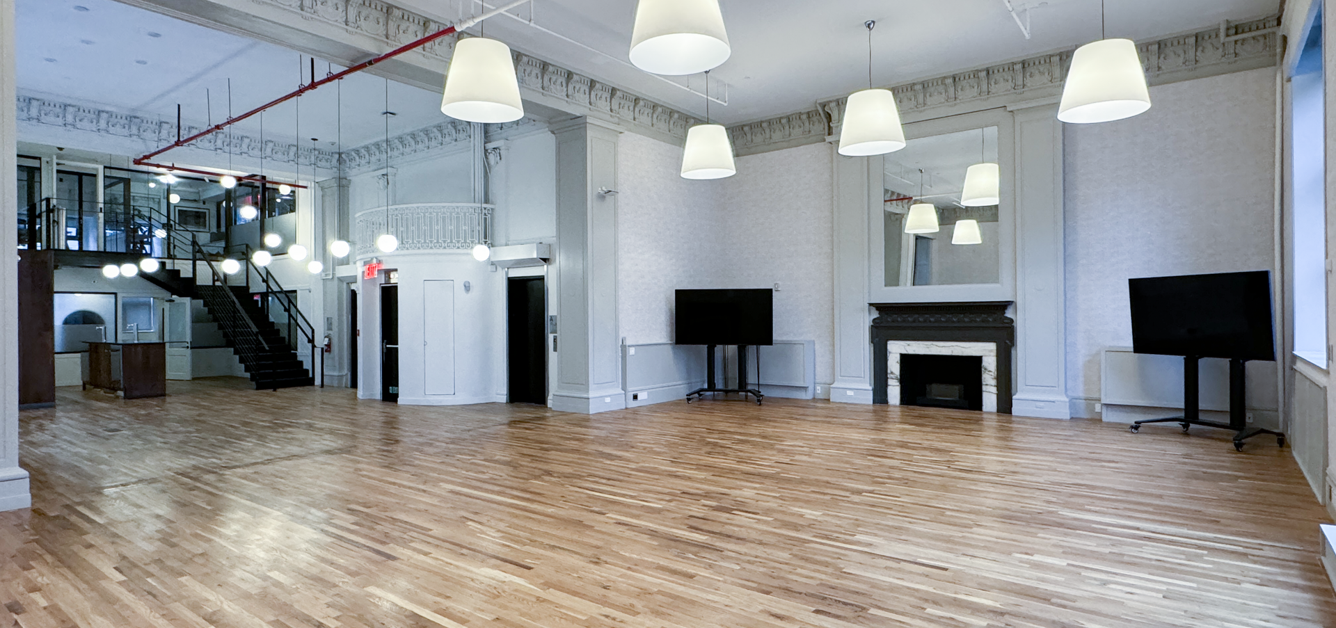 a large empty room with wooden floors and a fireplace .