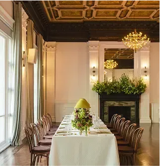 There is a long table with a lamp on it in the middle of the room.
