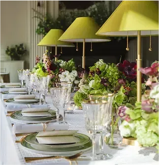 A long table with plates glasses and flowers on it