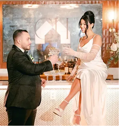 A bride and groom are toasting with champagne at their wedding reception.