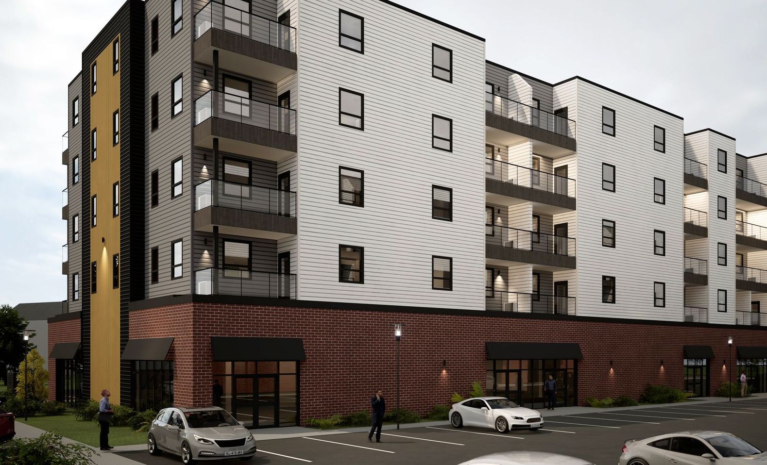 LOT 48 residential housing development in Stratford, PEI. Grey, yellow, and white facade with windows and balconies, parking lot.