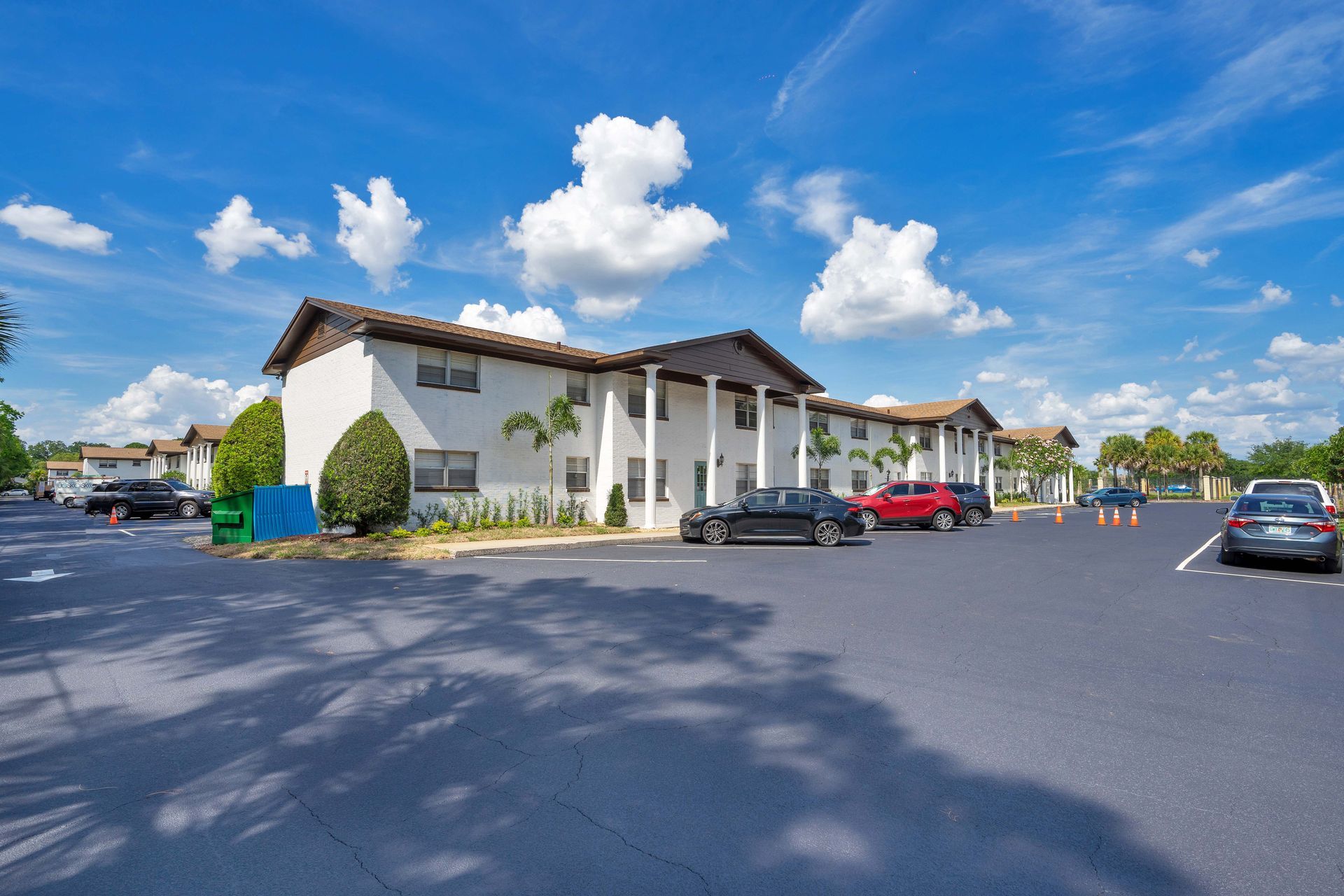 A large white building with cars parked in front of it.