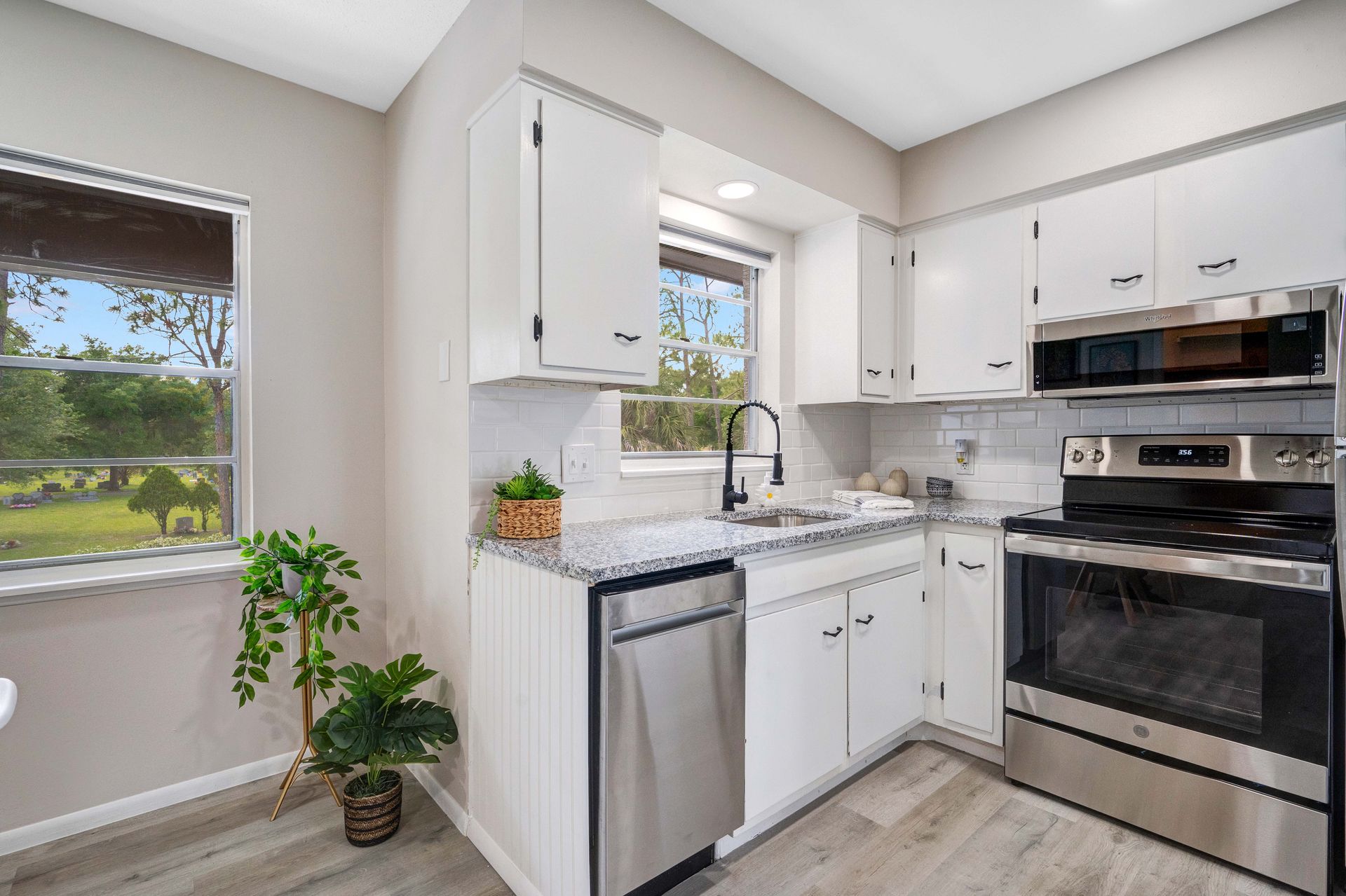A kitchen with stainless steel appliances and white cabinets.