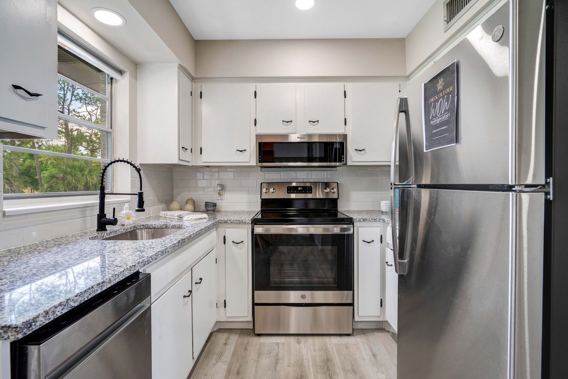 A kitchen with stainless steel appliances and white cabinets