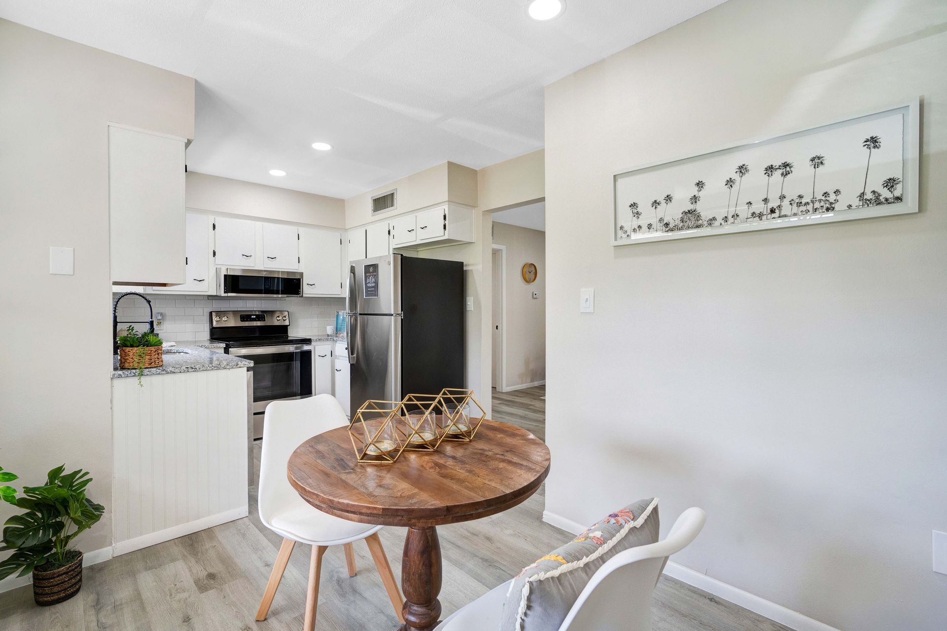 A kitchen with a wooden table and chairs in it.