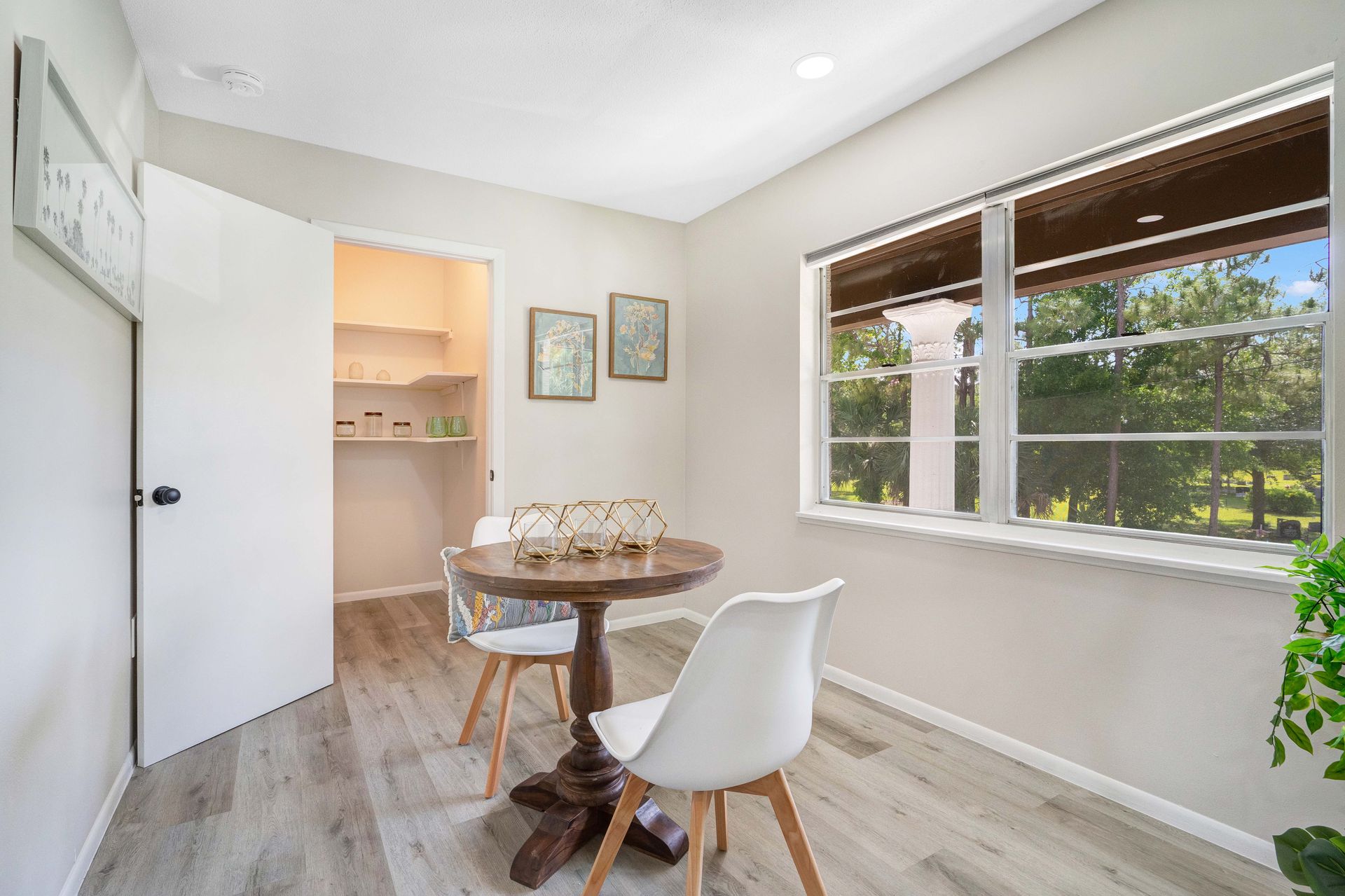 A dining room with a table and chairs and a window.