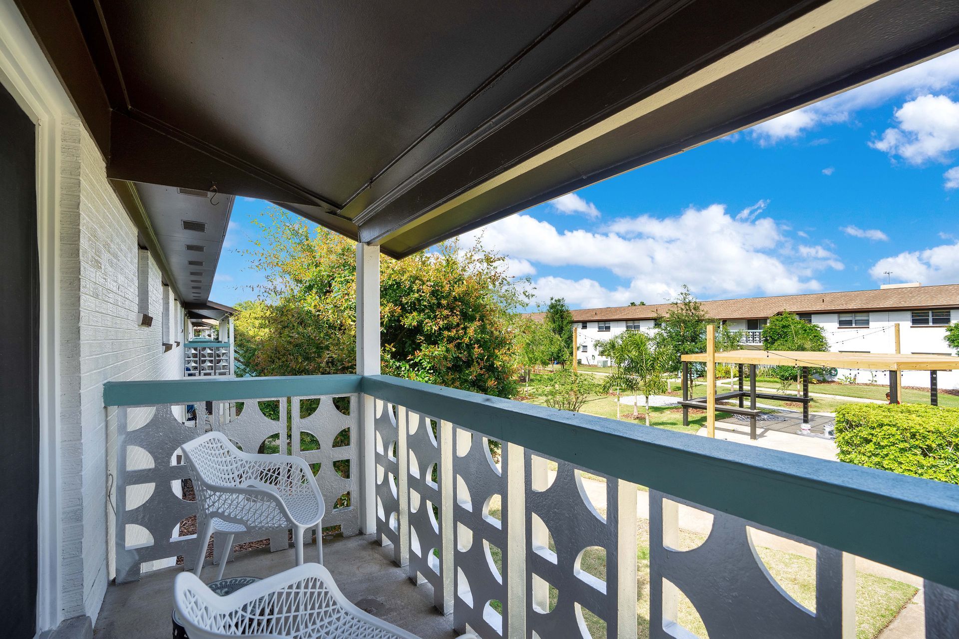 There is a balcony with a chair and a table on it.