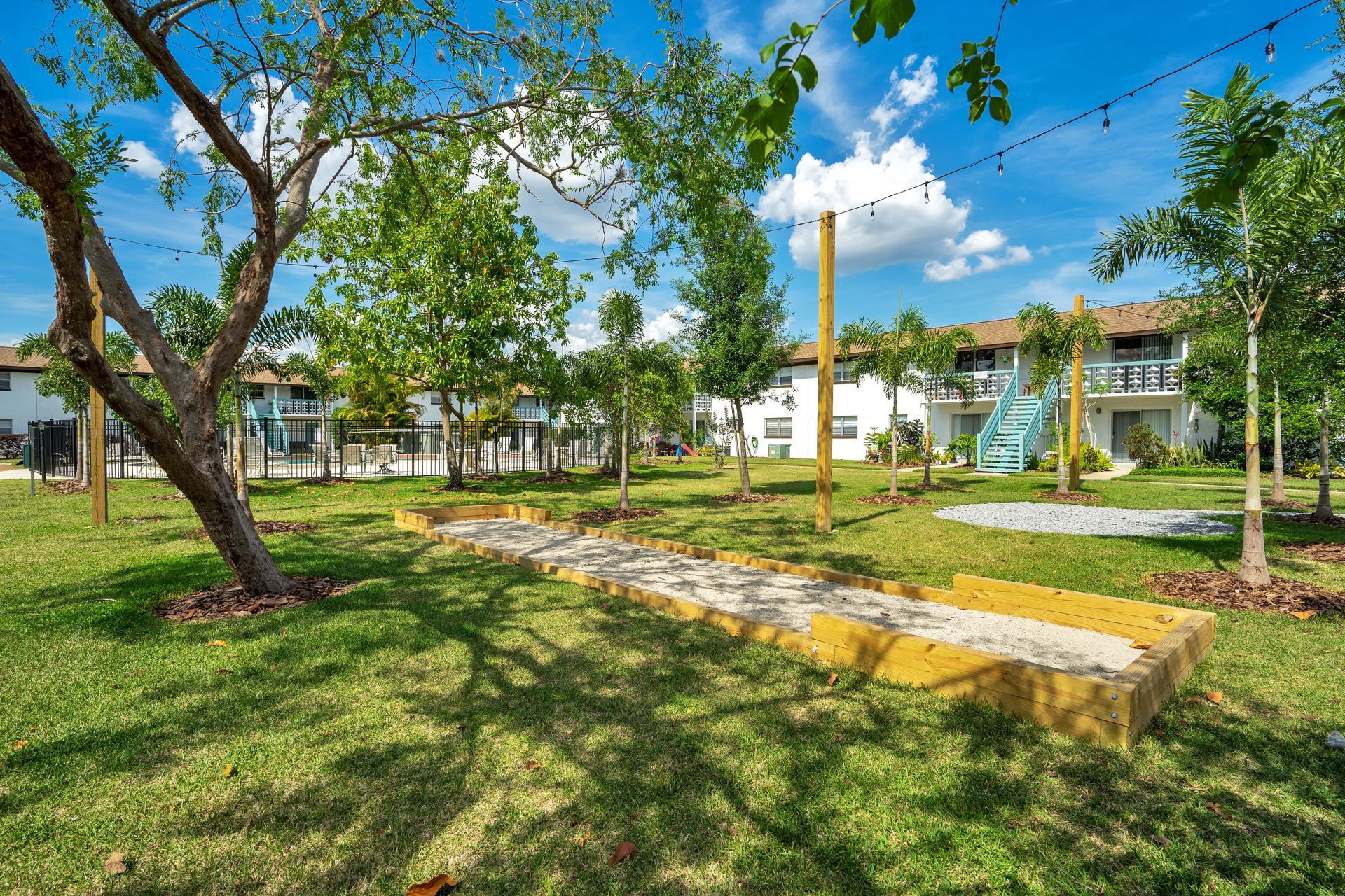 There is a sandbox in the middle of a grassy field.