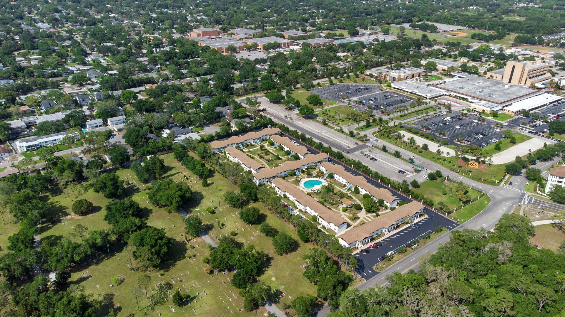 An aerial view of a residential area with a swimming pool in the middle of it.