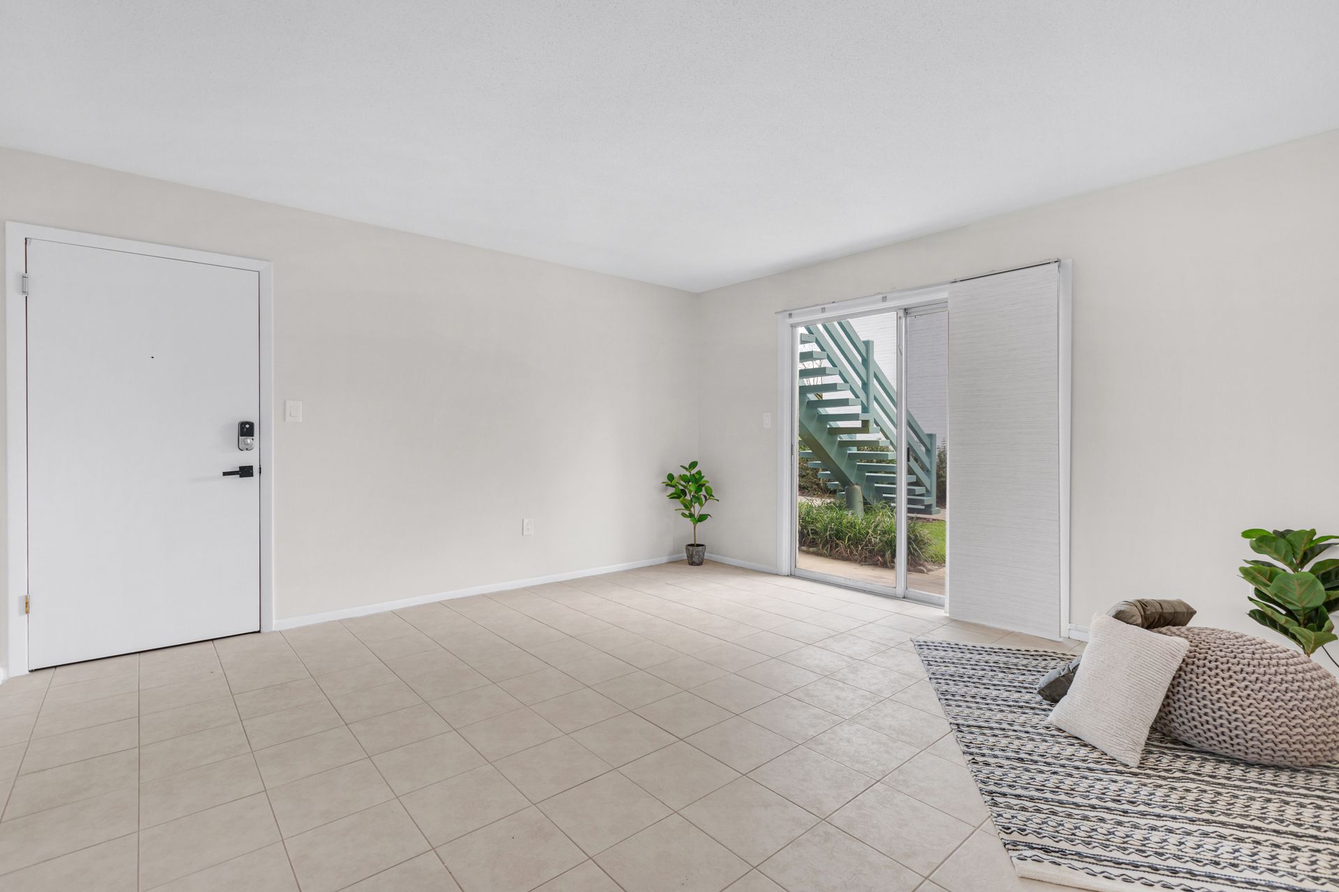 A living room with a couch , rug , and sliding glass doors.