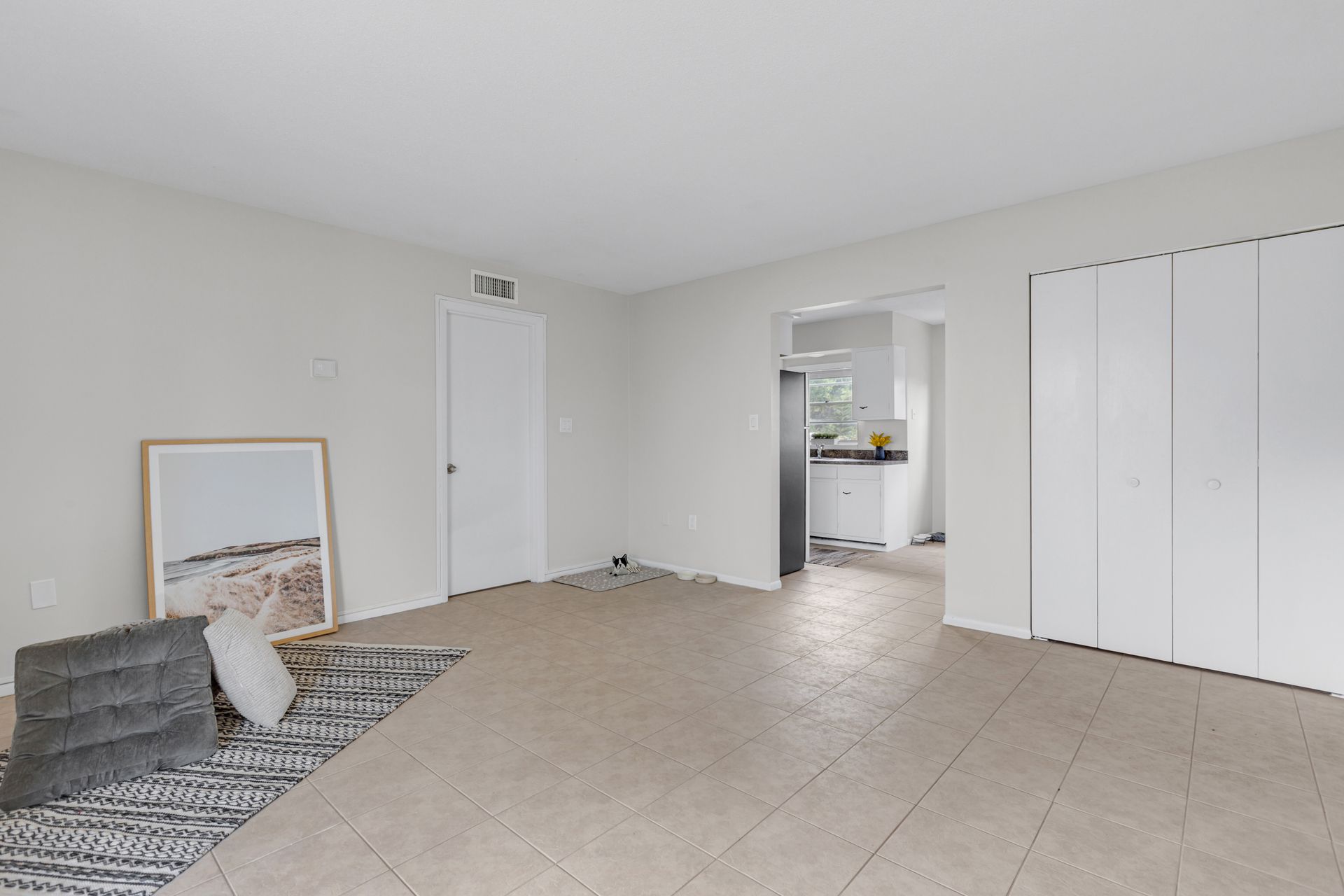 A living room with a rug and a picture on the wall.