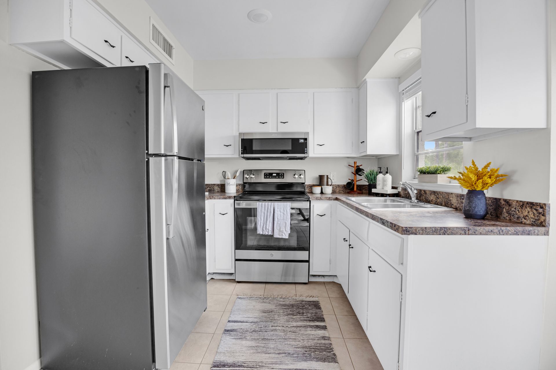 A kitchen with white cabinets and stainless steel appliances