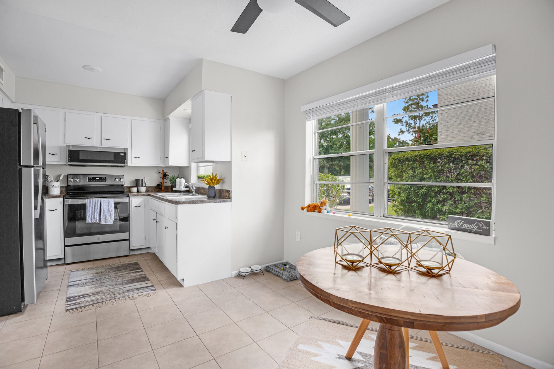 A kitchen with a table and a ceiling fan