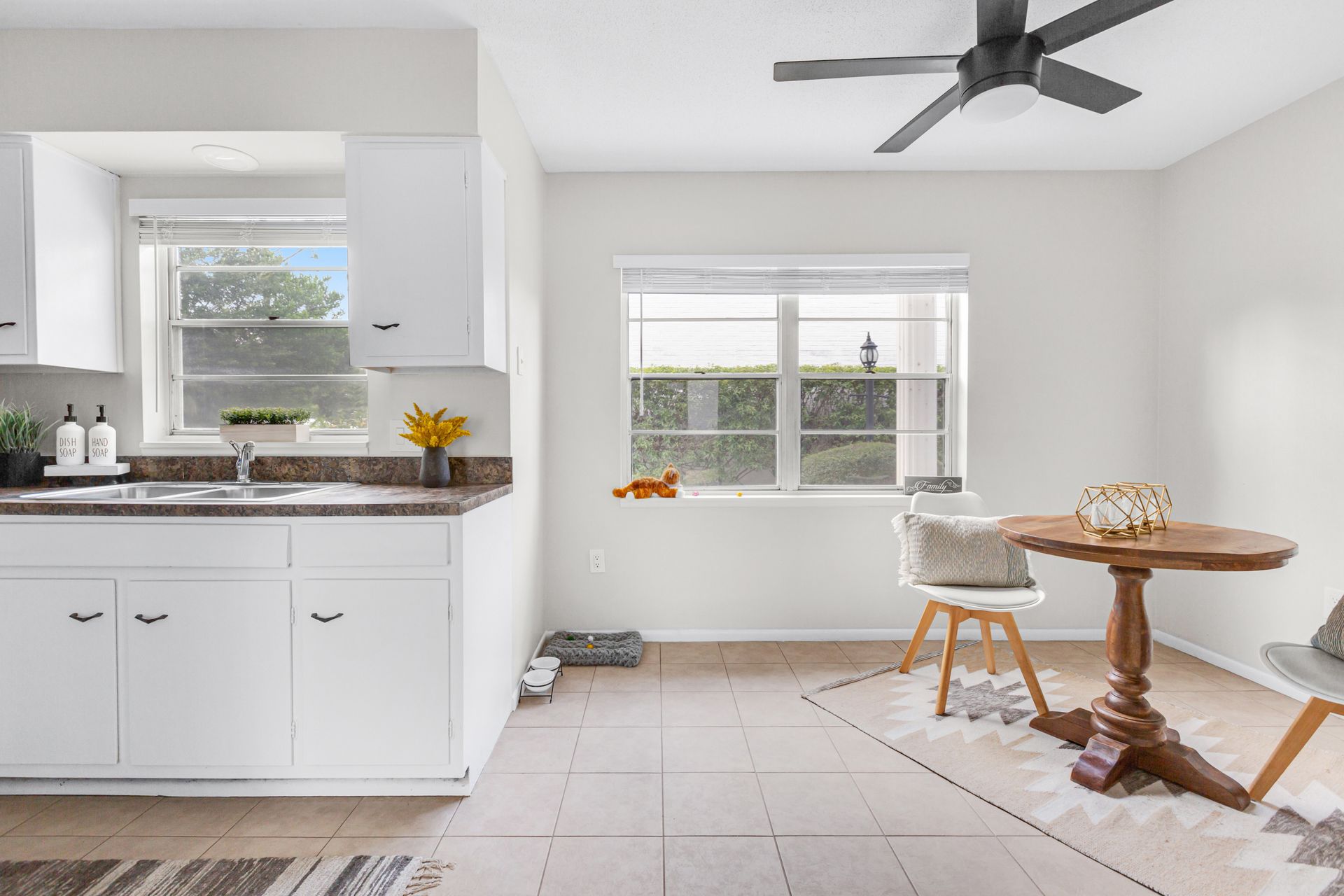 A kitchen with a table and chairs and a ceiling fan.