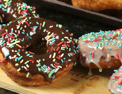 Um donut com cobertura de chocolate e granulado por cima