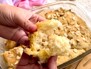 Uma pessoa está segurando um pedaço de pão com uma mordida.