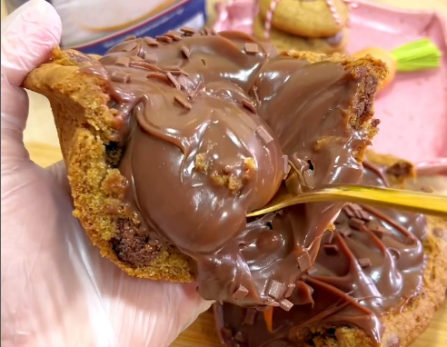 Uma pessoa está segurando um biscoito com cobertura de chocolate