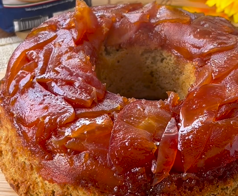 Um close de um bolo com fatias de maçãs no topo