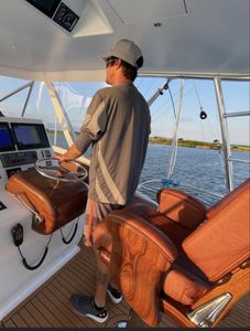 A man is sitting at the helm of a boat