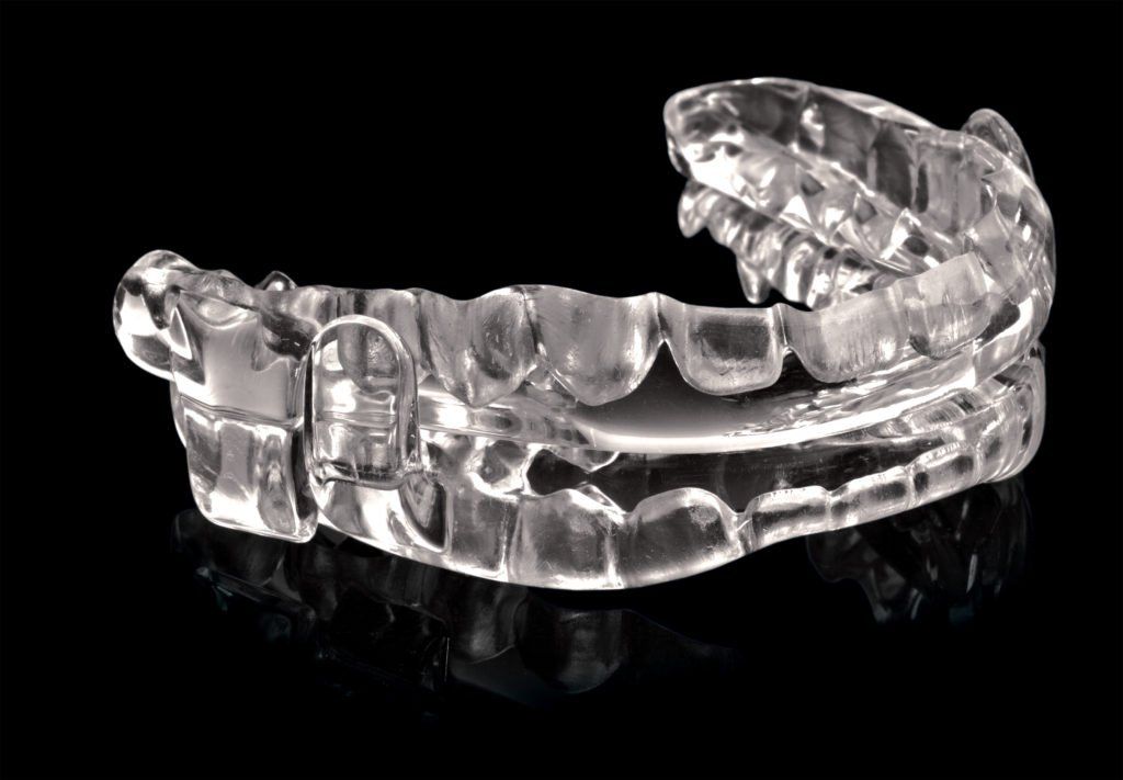Close up image of a clear oral appliance used for sleep apnea therapy.
