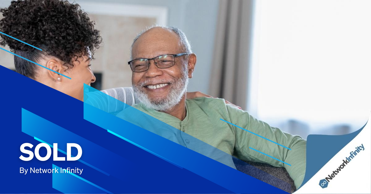A man and a woman are sitting on a couch and smiling after just selling their NDIS business.