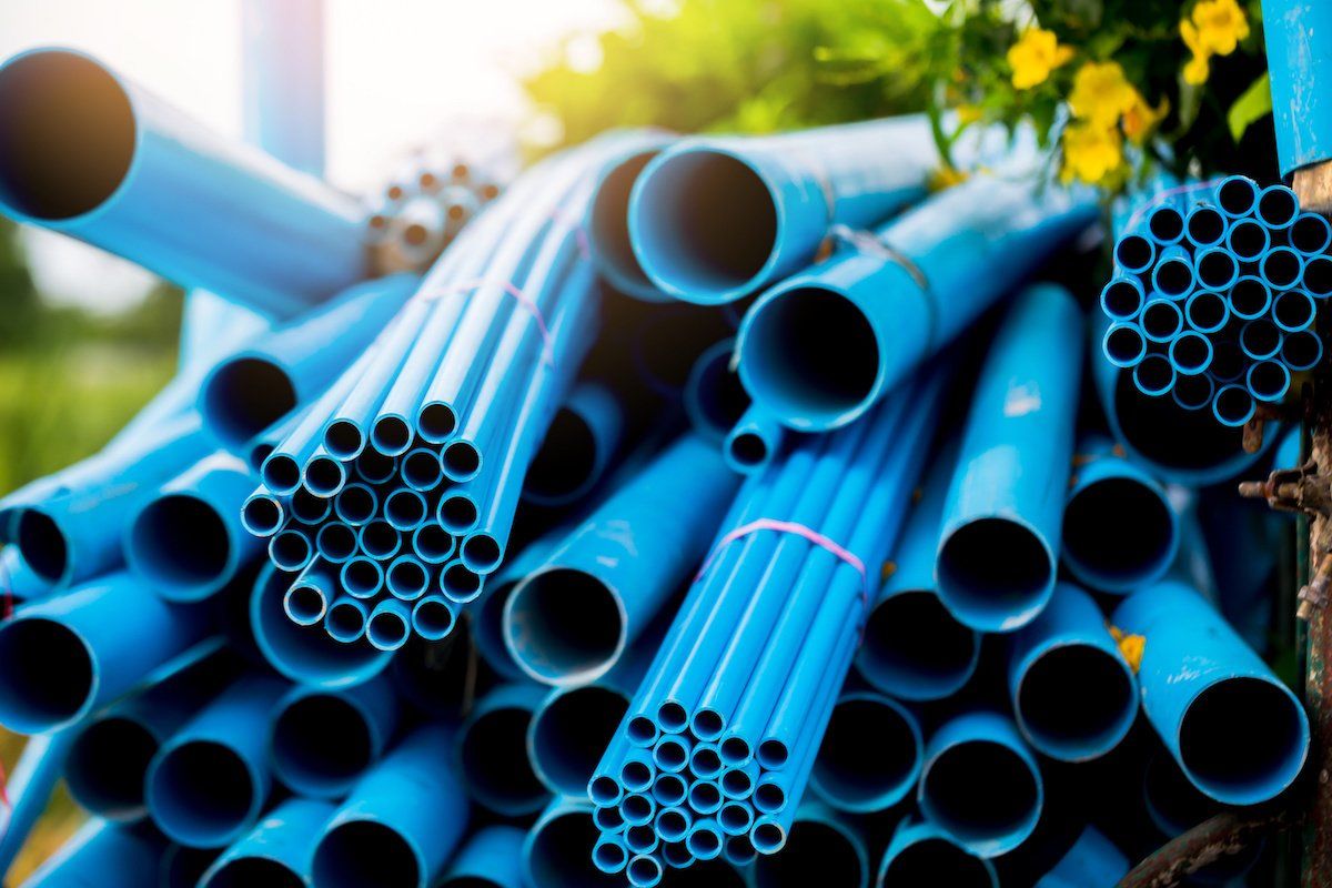A pile of blue plastic pipes sitting on top of each other.
