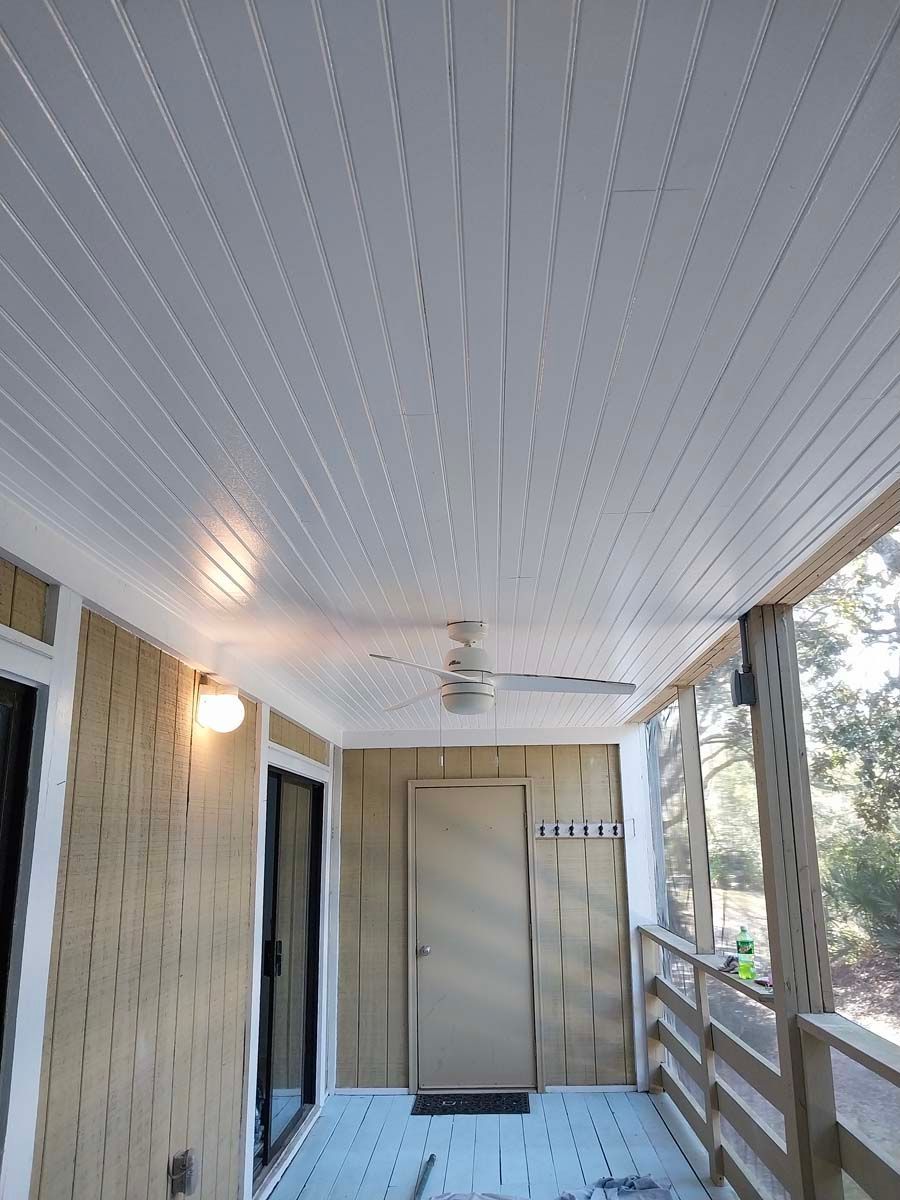 There is a ceiling fan on the porch of a house.