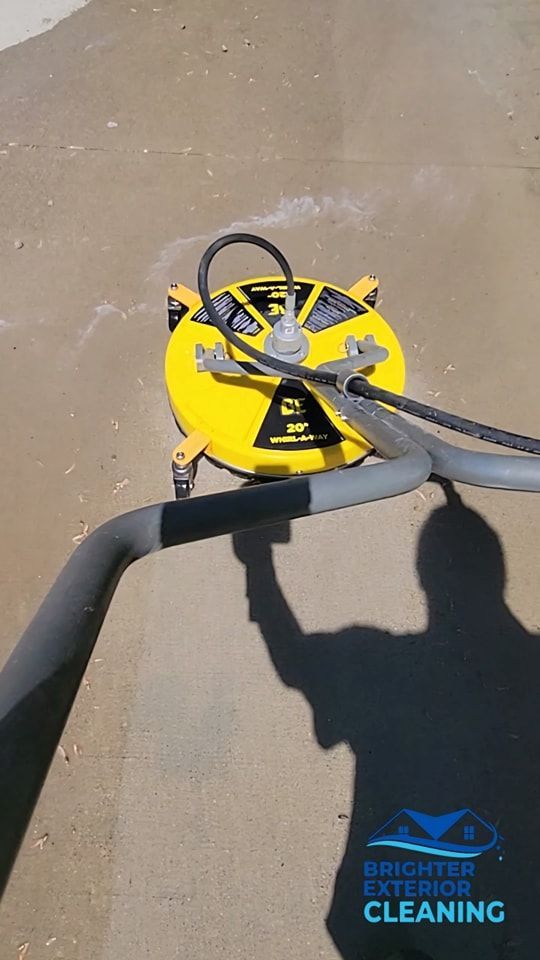A person is using a machine to clean a concrete surface.