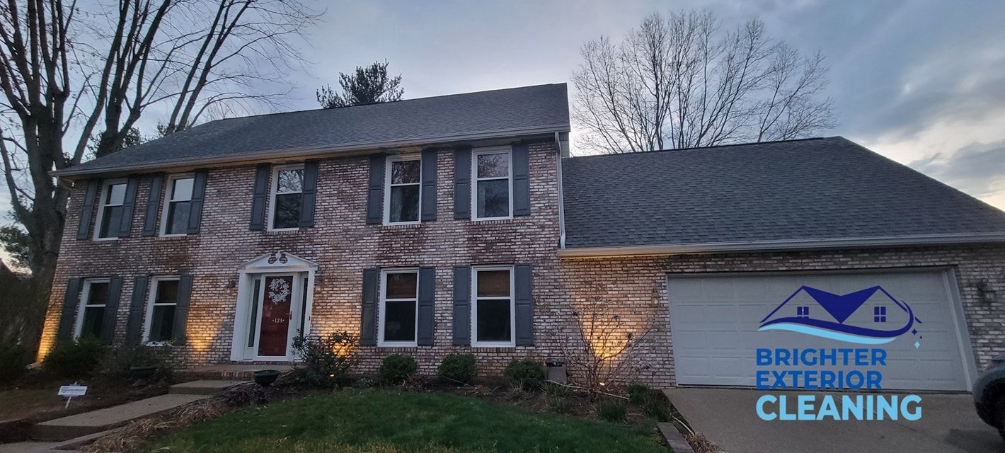 A large brick house with a roof that has been cleaned by brighter exterior cleaning.