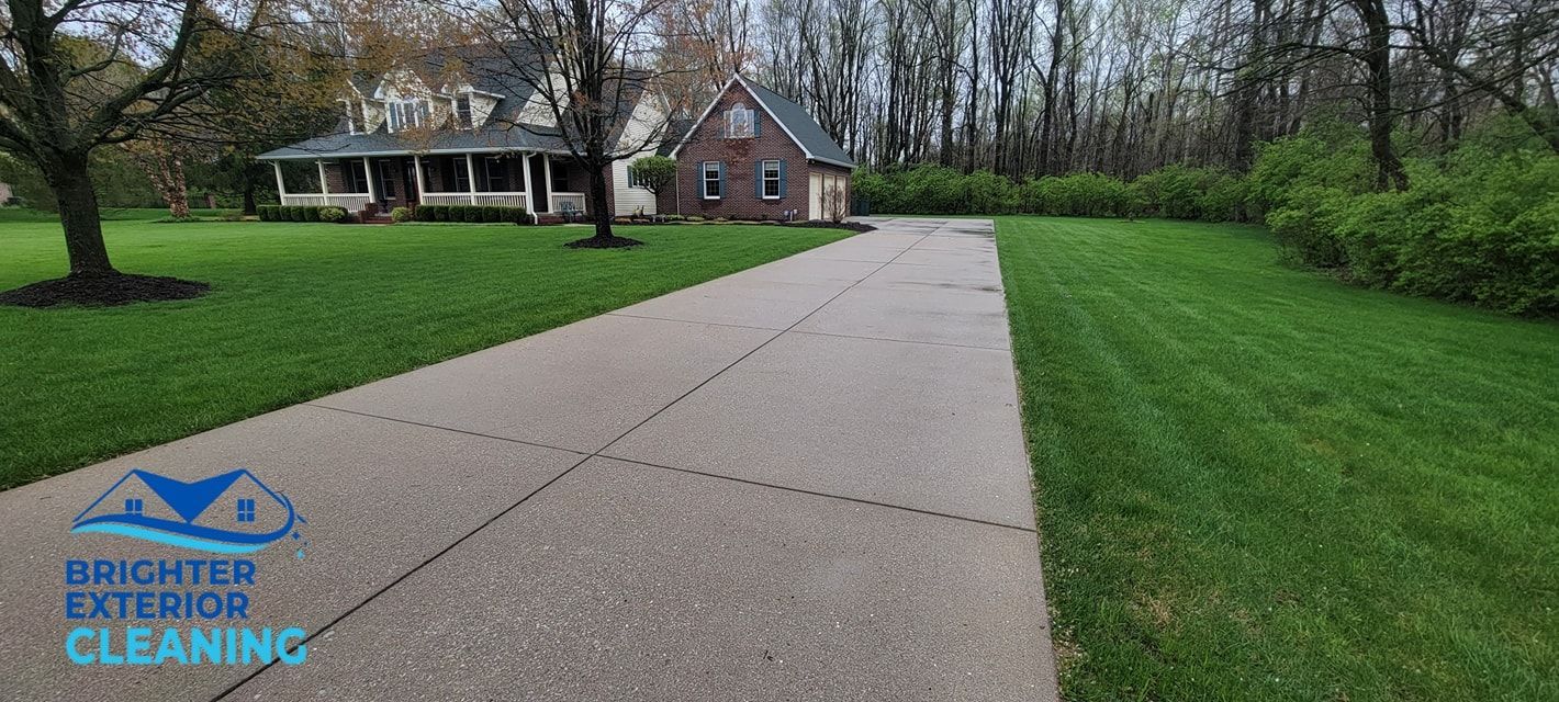 A driveway leading to a house with a lot of grass.