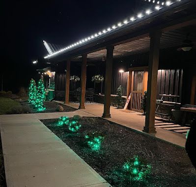 A house with a porch and christmas lights on it at night.