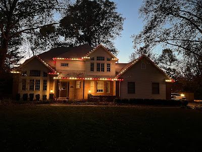 A large house is lit up with christmas lights at night.