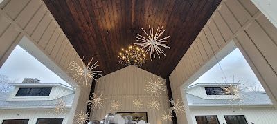 A large wooden ceiling with a chandelier and snowflakes hanging from it.