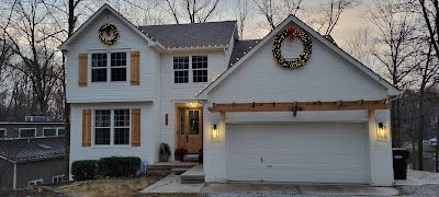 A white house with a christmas wreath on the roof.