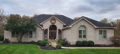 A large brick house with a wreath on the front of it.