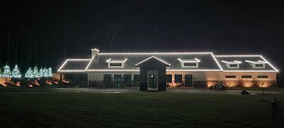 A large house is lit up with christmas lights at night.