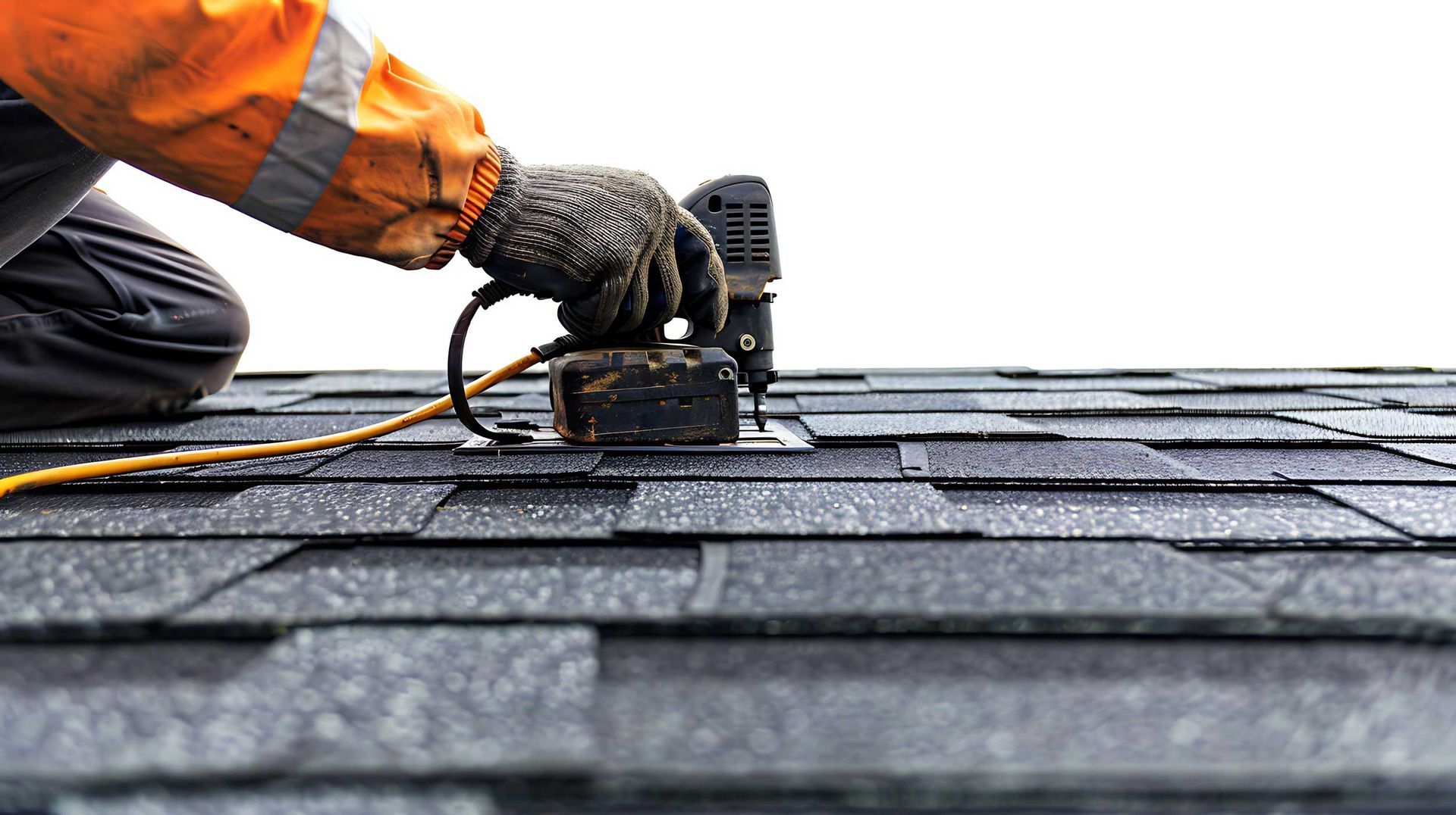 Roofing contractors installing asphalt shingles using nail gun on residential roof close-up.